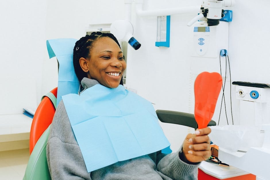 Smiling woman holding a mirror during a dental check-up