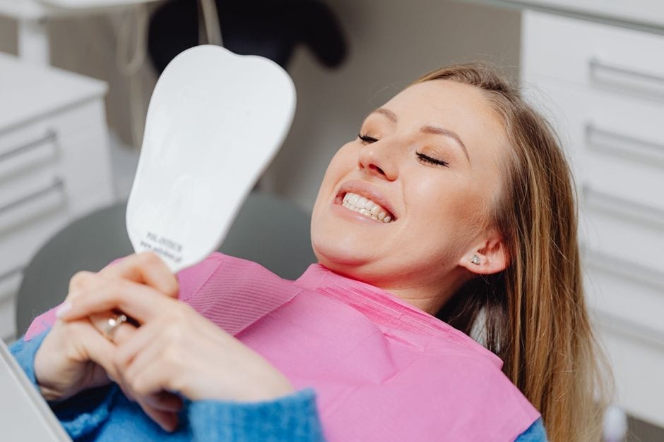 Woman smiling at dental clinic showing cosmetic dentistry results