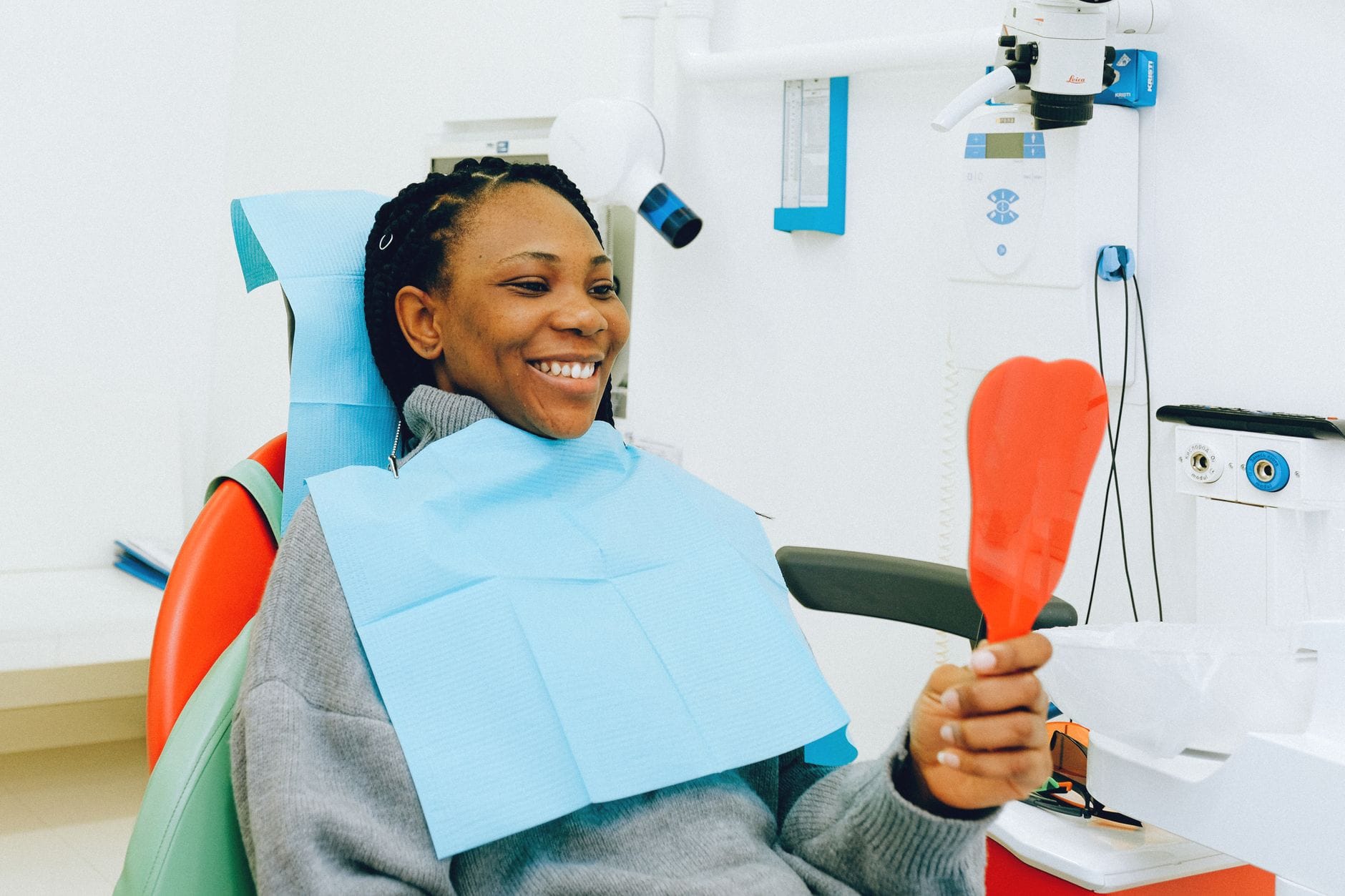 Patient reviewing smile with mirror during dental checkup